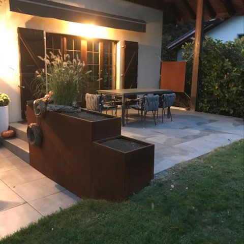 Séparation entre la terrasse et l’entrée de la maison par deux bacs de hauteur différente